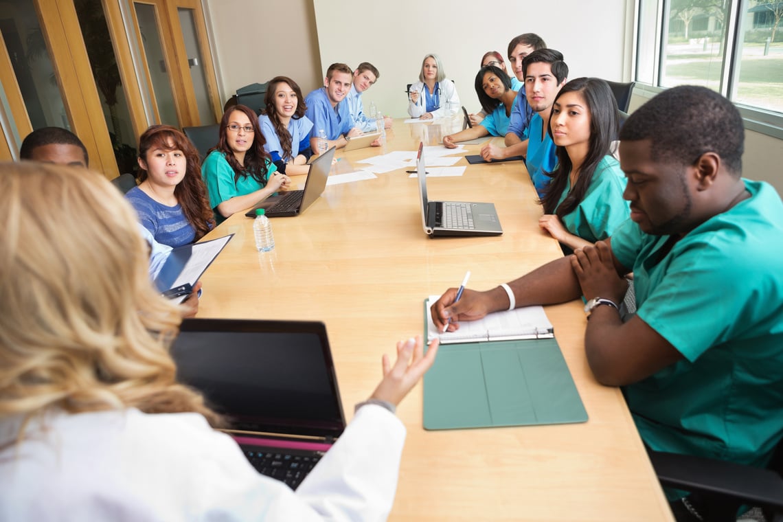 Doctors and nurses having hospital staff meeting in board room